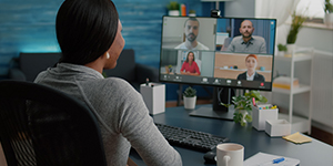 A girl discussing with team having virtual teleconference meeting sitting at desk in living room because she remote work.